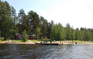 伊卡利宁Camping Toivolansaari的和人一起在湖岸上的船