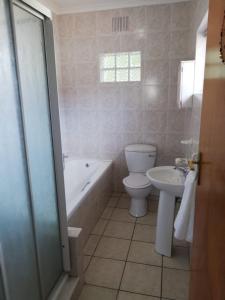 开普敦Coons Cove的浴室配有卫生间、浴缸和水槽。