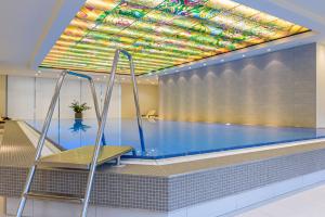 不莱梅玛丽蒂姆不来梅酒店的一个带色彩鲜艳的天花板的游泳池