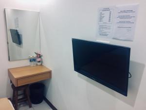哥打京那巴鲁阿皮阿皮旅馆的挂在桌子旁墙上的平面电视