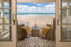 纽基Tolcarne Beach Colonial Restaurant and Rooms的从海滩房屋的阳台上可欣赏到海滩景色