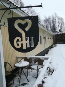 RaisioGasthaus Henri的雪中房子的一侧的标志
