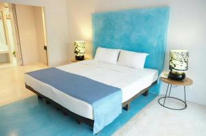华欣Kocchira的一间卧室设有一张蓝色墙壁的大床