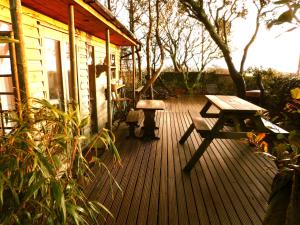金斯布里奇Sunset Lodge的木甲板上设有野餐桌和长凳