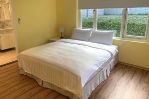 台北阳明山美国渡假村的卧室配有一张大白色床和窗户
