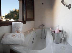 格拉纳达帕拉西奥德圣伊内斯酒店的白色的浴室设有浴缸和窗户。