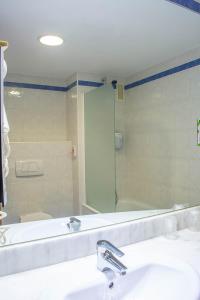 阿尔卡拉德荷那利斯马德里钟楼阿尔卡拉德埃纳雷斯酒店的浴室设有镜子、水槽和浴缸