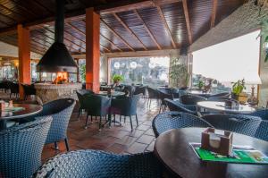 卡索拉Hotel & Spa Sierra de Cazorla 4*的一间带桌椅和壁炉的餐厅