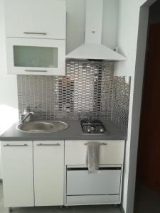斯维诺乌伊希切Iwona的白色的厨房设有水槽和炉灶。