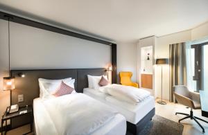 诺伊斯Crowne Plaza Düsseldorf - Neuss, ein IHG Hotel的酒店客房,配有两张床和椅子