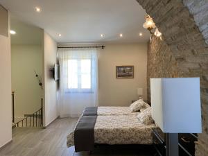 莱斯卡拉Casa de piedra adaptada en LEscala的一间卧室设有一张床和石墙