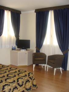 奥瓦达贝勒佛瑞特酒店的一间卧室配有床、电视和窗帘