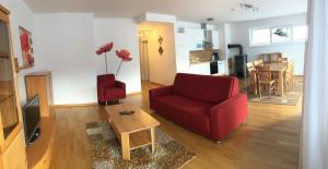 索内纳尔佩·纳斯费尔德Sonnenalpe Apartments Nassfeld的客厅配有红色的沙发和桌子