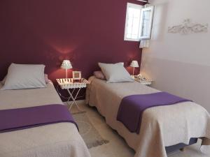 圣萨蒂南艾普特Le Mas de l'Escaillon的紫色墙壁客房的两张床
