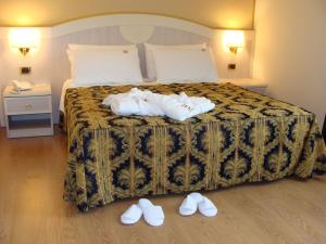 奥瓦达贝勒佛瑞特酒店的酒店客房的地板上配有一张带拖鞋的床。