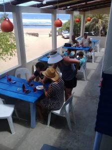 赛赛Nascer Do Sol - Chizavane的一群坐在海滩桌子上的人