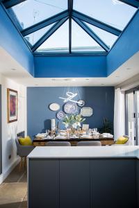 格莱顿The Cottage and The Nook的一间拥有蓝色天花板和餐桌的用餐室