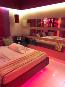 布宜诺斯艾利斯Origen Hotel -Motel-的一间卧室配有两张床,配有粉红色的灯光