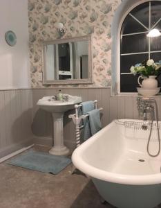克拉姆林Ballyginniff Farm House的带浴缸、水槽和镜子的浴室