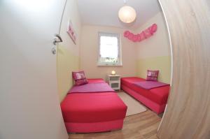 马林费尔德Ferienhaus Müritzzauber / EG-Appartement的小房间设有两张床和窗户
