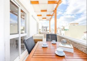 法鲁My Place @ Faro Ria Views的阳台上的木桌和椅子