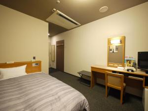 小牧市格兰蒂亚小牧路线酒店的酒店客房配有一张床、一张书桌和一台电视。