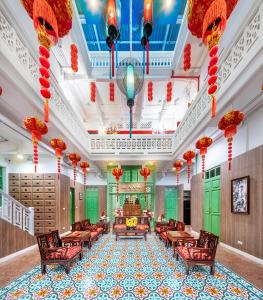曼谷曼谷阿玛旅馆的大型大堂设有红色灯笼和桌椅