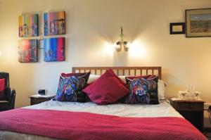 East CalderAshcroft Farmhouse的一间卧室配有一张带粉色床单和枕头的床。
