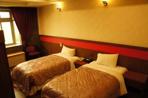 Mailiao巴黎汽车旅馆的酒店客房设有两张床和窗户。