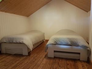 埃尔伯蒙Woodstone的小型客房铺有木地板,配有两张床。
