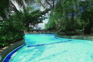 安博塞利Amboseli Serena Safari Lodge的一座拥有蓝色海水和树木的大型游泳池