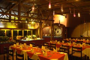 安博塞利Amboseli Serena Safari Lodge的用餐室配有桌椅和灯光