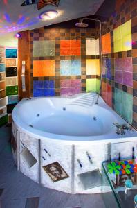 PanzaresAnahuaska Art - Suites Temáticas的色彩缤纷的瓷砖房内的大浴缸