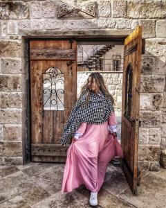 格雷梅马赛克洞穴酒店的坐在门前身穿粉红色衣服的女人