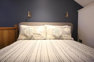伊尔弗勒科姆The Well house的一间卧室配有带白色床单和枕头的床。
