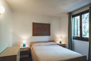 罗通多港Residence Portorotondo Tre的一间卧室配有一张床和两张带台灯的桌子。