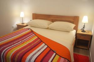普利莫顿Apartments Toni Sea view的一间卧室配有一张带彩色毯子的床