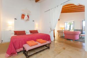 阿尔盖达Oliver Moragues Grandhouse & Vineyard的一间卧室配有一张带粉色毯子的大床