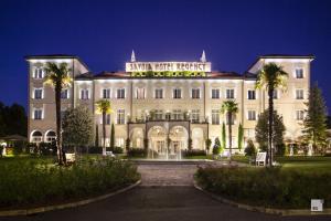 博洛尼亚萨沃亚摄政酒店的一座棕榈树环绕的大建筑
