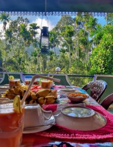 埃拉Cozy Homestay Waterfall Road Ella的一张桌子,上面放着食物,享有棕榈树的景色
