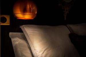 梅斯L'Appartement des Roches的挂在床上的灯和白色枕头