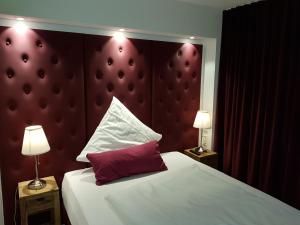 AdelbergGasthof Krone的一间卧室配有一张带红色床头板的床和两盏灯。