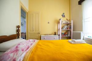 纳夫普利翁Tis Mammis的一间卧室配有一张带黄色毯子的大床