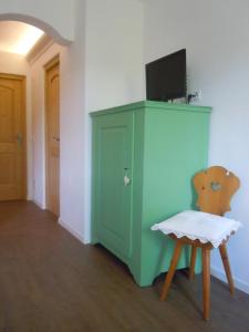 修希Feldererhof的一间设有绿色橱柜和椅子的客房