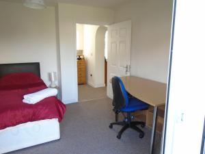 利物浦TEA in Liverpool - Private - Quiet - Ground Floor - En-suite - Walk-in-shower的一间卧室配有书桌、一张床和一张桌子