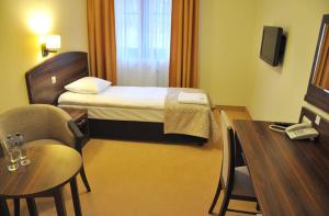MniówHotel Dudek的酒店客房,配有一张床、一张桌子和椅子