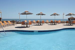 大西洋城Boardwalk Resorts at Atlantic Palace的一个带桌椅和遮阳伞的游泳池