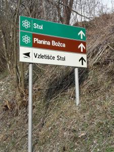 SedulaAPARTMA SABOTIČ的山坡上绿色和白色的街道标志