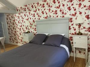 沙伯伊Le Dauphin的卧室配有一张挂着红色鲜花的床。