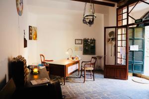 福纳卢奇Can Pera Accommodation - TI的客厅配有桌椅和书桌。